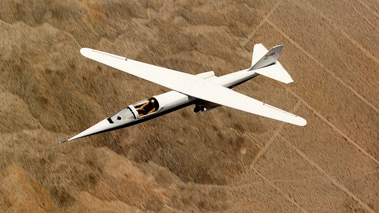 NASA Ames-Dryden AD-1 research jet in flight over the desert with its wing pivoted to 60 degrees, the maximum sweep