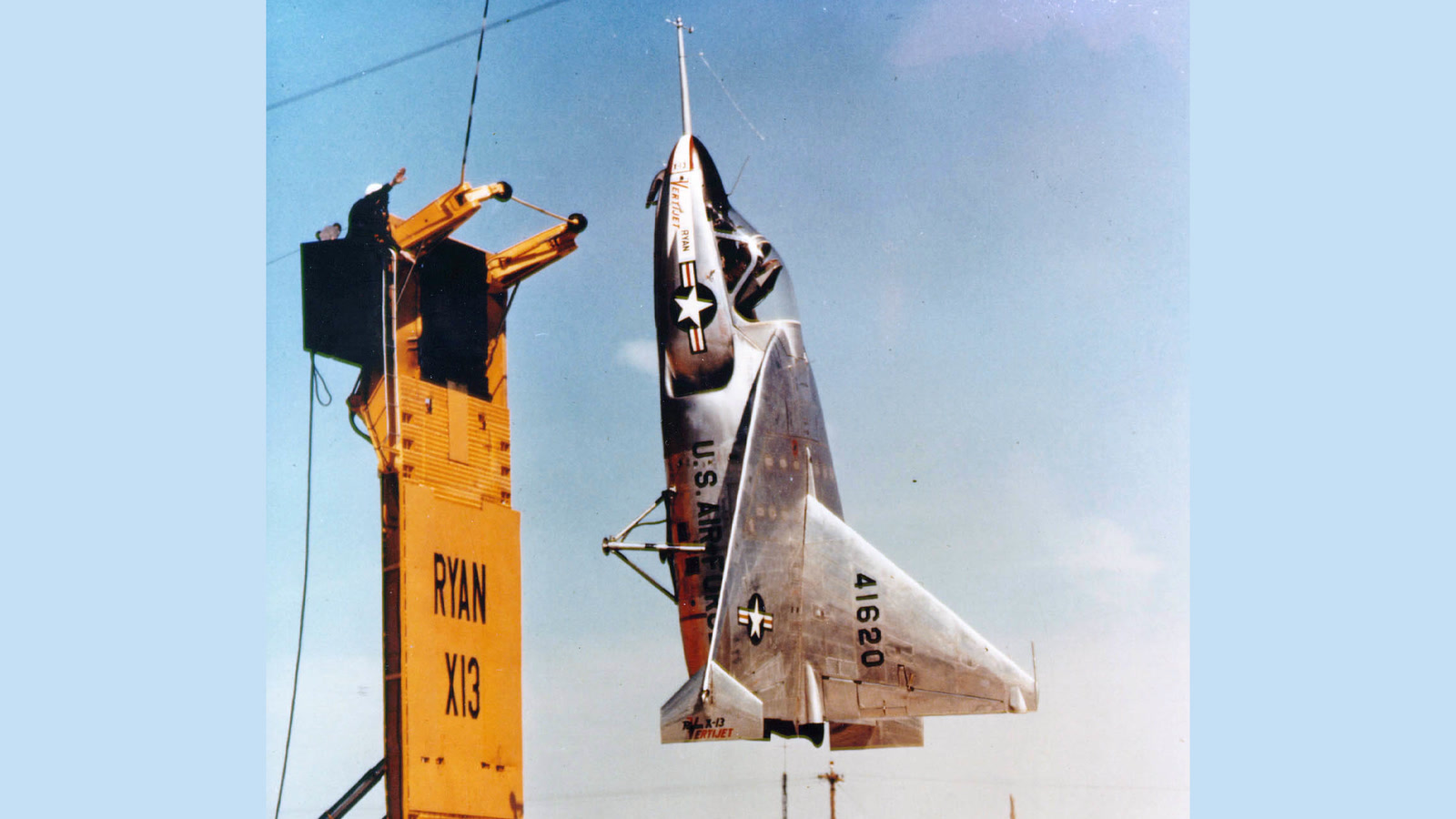 Ryan X-13 Vertijet second prototype 54-1620 hanging vertically beside its yellow dual-role transport and launch trailer, about to hook on